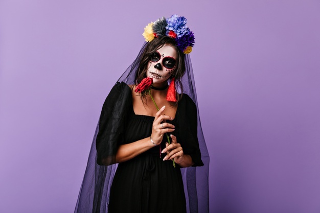 mysterious-mexican-woman-in-dress-of-black-widow-posing-on-lilac-wall-photo-of-girl-with-crown-of-flowers-and-bright-earrings_197531-16118.jpg